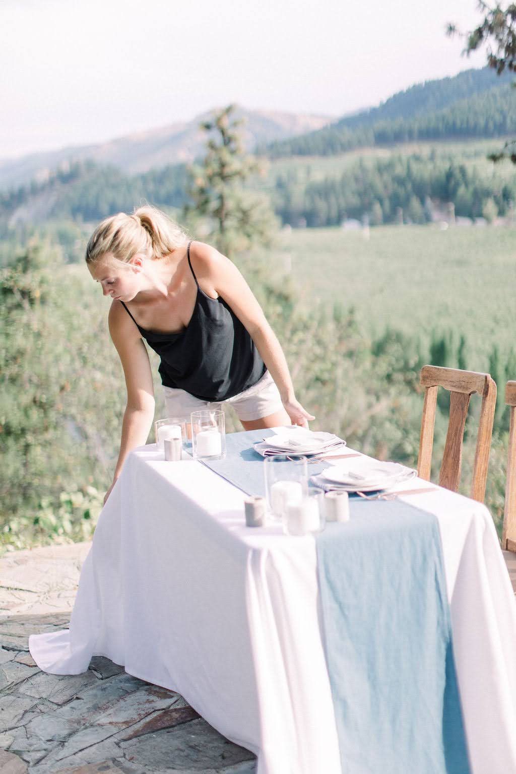Ashley setting up a reception table with mountain views